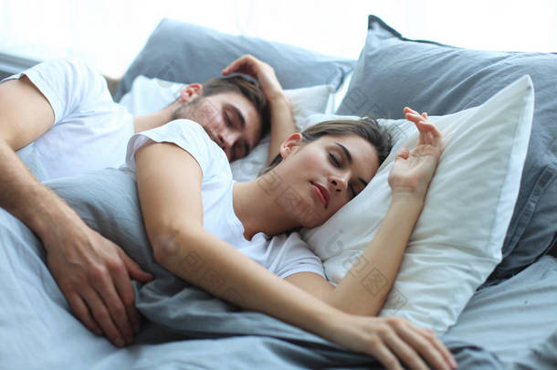 幸福的夫妇在家里舒适的床上睡觉.