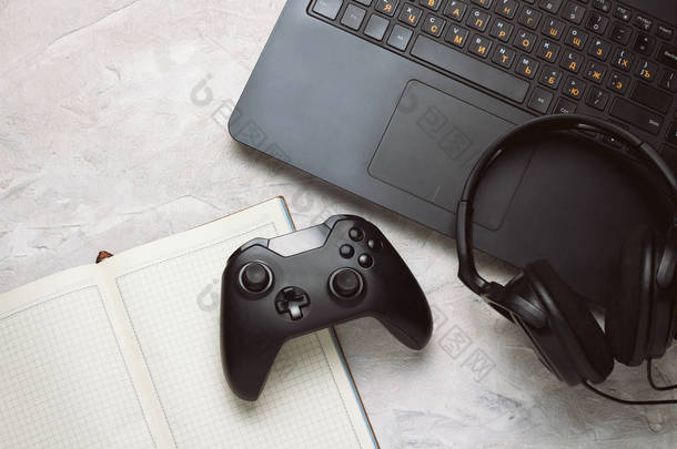 手柄, 笔记本电脑和耳机, 杯子与咖啡和笔记本在一个白色的桌子上, 复制空间。游戏玩家背景概念.