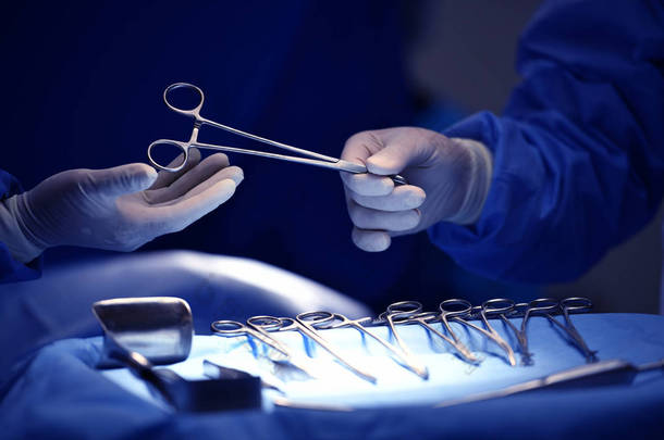 外科医生手拿起手术器械托盘上的仪器