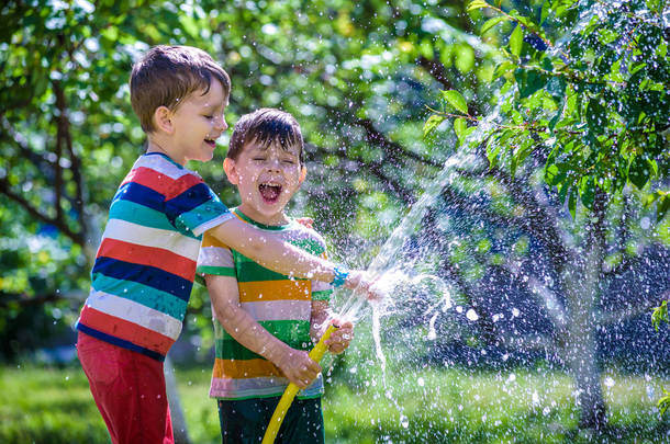 可爱的小男孩在花园里给植物浇<strong>水</strong>。可爱的小孩子, 帮助父母种植树木和享受乐趣。户外儿童<strong>活动</strong>.