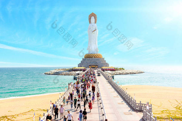 中国三亚- 2020年1月21日：一群中国游客走过大桥，<strong>走向</strong>南山佛教文化中心的观音女神神像
