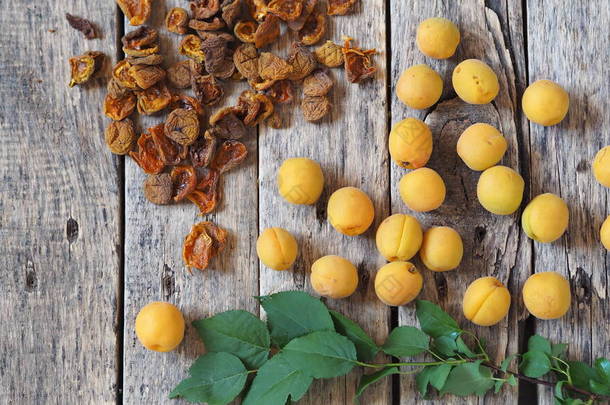健康的天然食品。我们自己准备干杏仁.烘干机上的干杏仁、新鲜的杏仁和木制天然桌子上的绿叶小枝.