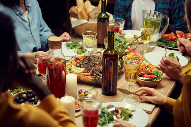 与难以辨认的人一起享用晚餐，把注意力集中在美味的自制食物和放在木制桌子上的葡萄酒上，复制空间