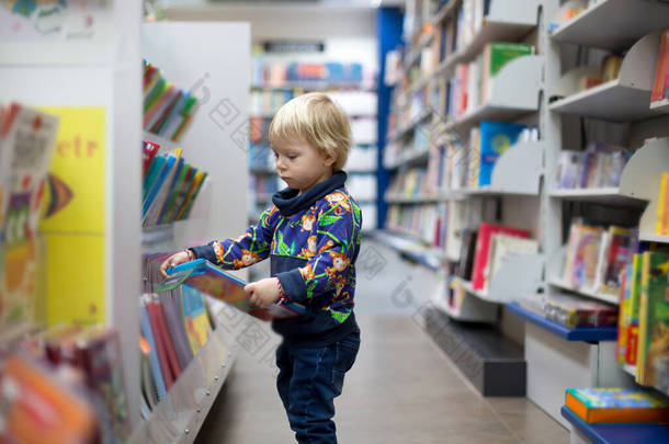 可爱的小男孩，坐在书店里看书