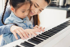 亚洲年轻钢琴师老师教女生弹钢琴，音乐教育理念