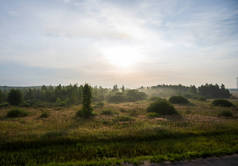 早晨，在建筑物、树木和田野的雾气中，日出了