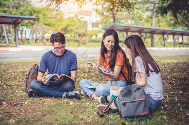 亚洲大学生小组在户外草地上读书和辅导专门班。幸福与<strong>教育</strong>学习<strong>理念</strong>。回到学校的概念。青少年和人主题.