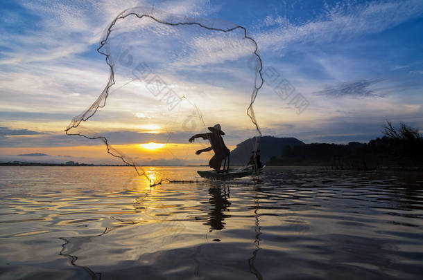 亚洲传统渔民在行动清晨自然河里捕鱼在日出时的剪影时 senrise 时间