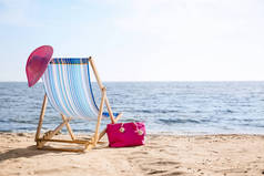 休闲椅、帽子和包在海边的沙上，有文字空间。海滩对象