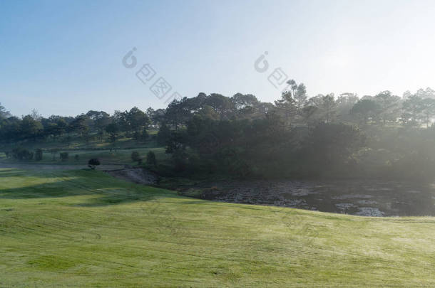背景与<strong>美丽</strong>的绿色草地和黄色的阳光, 雾覆盖草山。照片用于高尔夫球场设计理念, 旅游, 广告