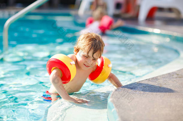 快乐的小男孩在游泳池里玩得很开心。积极快乐<strong>健康</strong>学龄前儿童学习游泳。<strong>与安全</strong>的浮雕或游泳。家庭, 假期, 夏天的概念