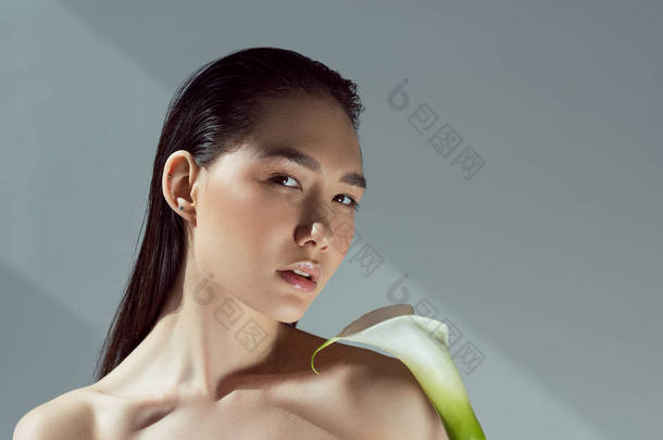 美丽的裸嫩亚洲女孩与马蹄莲花, 孤立的灰色