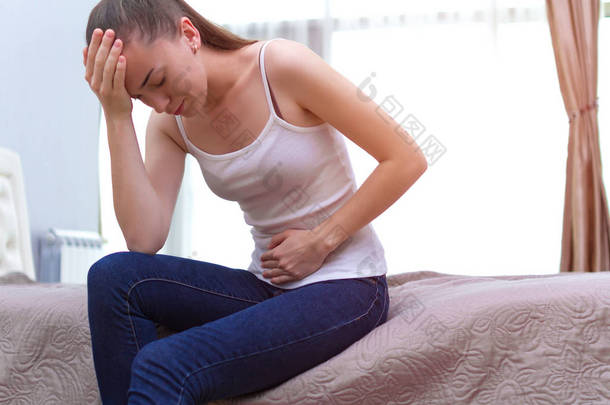 年轻女子在 p m 和月经期间感觉不好, 会出现腹痛。痛苦的月经。炎症和膀胱感染