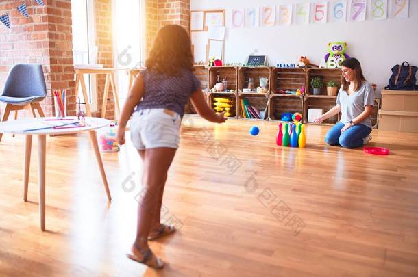 漂亮的老师和幼儿在幼儿园打保龄球