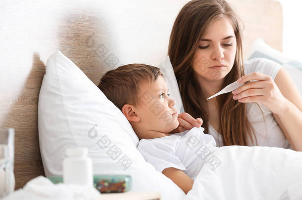 母亲<strong>测量</strong>她儿子在家患流感的温度