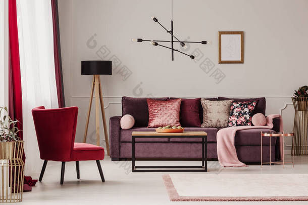 <strong>红色</strong>扶手椅靠近木桌和紫色沙发对<strong>墙</strong>与样机在客厅内部