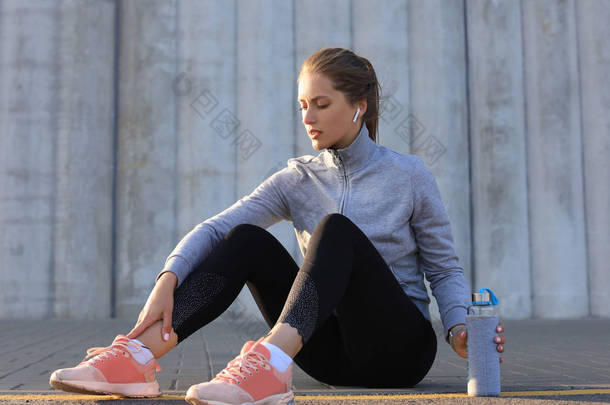运动服装的漂亮年轻女子在户外运动后喝<strong>水</strong>