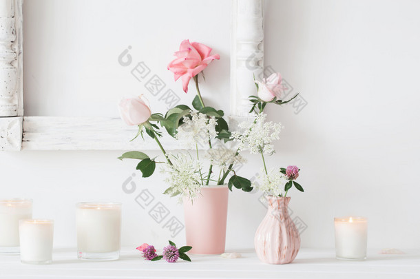 花在花瓶里和白色背景上的蜡烛