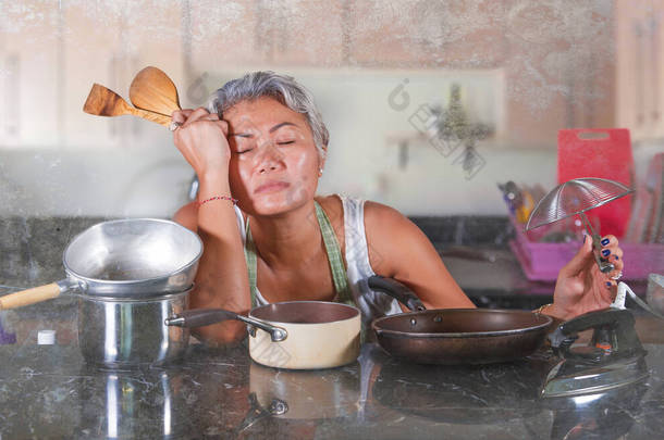 有吸引力的心烦意乱的女人40到50多岁的时候，在家里的厨房里既累又不快乐，做家务活，做无趣的家务活，手忙脚乱