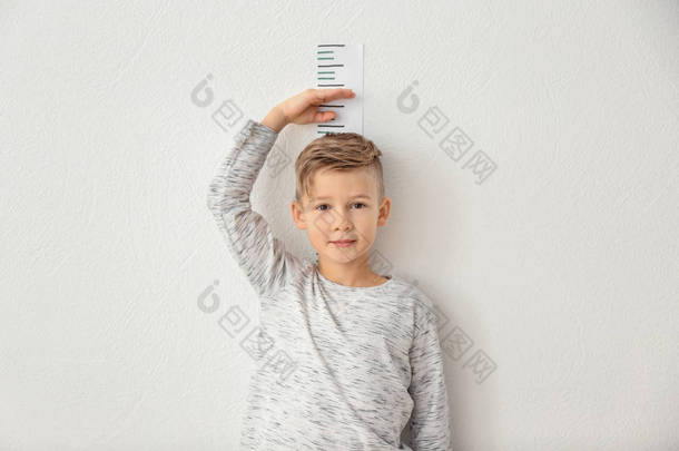 小男孩测量轻墙附近的高度