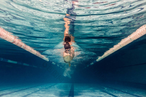 <strong>泳池游泳</strong>帽及护目镜训练中的年轻<strong>游泳</strong>者水下图片
