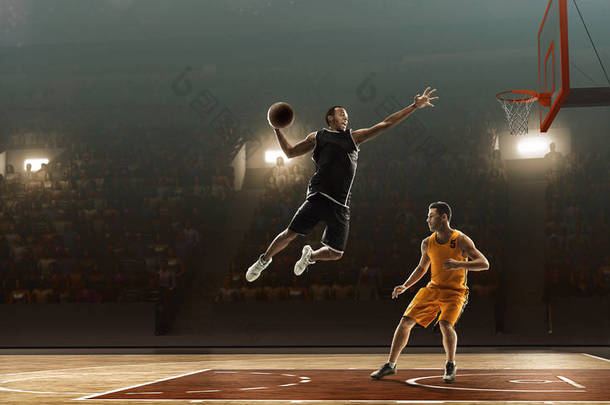 两个篮球运动员在球圈附近。非洲裔美国球员做扣篮
