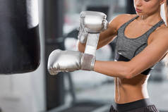 运动拳击手戴银拳击手套在健身房的裁剪图像