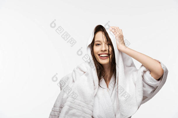 快乐的女孩一边用白色毛巾擦拭湿透的干净头发，一边看着被白色隔离的相机