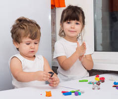 四岁的孩子和蹒跚学步的男孩在家里或幼儿园玩耍.