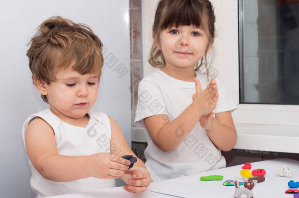 四岁的孩子和蹒跚学步的男孩在家里或幼儿园玩耍.