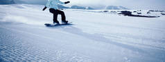 一个滑雪板滑雪板下降在冬季山区