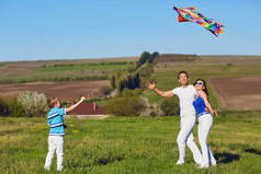 快乐的家庭与风筝在自然领域里演奏
