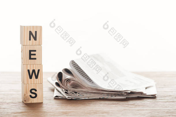 木制立方体与文字新闻和报纸在木桌面