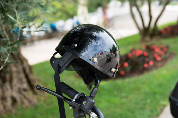 电单车的后视镜上挂着一个防护头盔.有选择的重点.