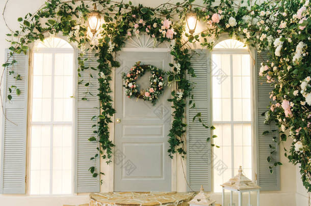 有窗户的房子的门廊装饰着美丽的绿色花朵和春天的装饰