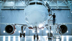品牌新飞机站在飞机维修机库同时飞机维修工程师 / 技术员 / 技工走进舱通过梯子 / 坡道.