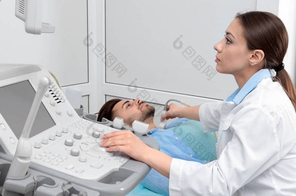 医生在诊所对病人颈部进行超声波检查