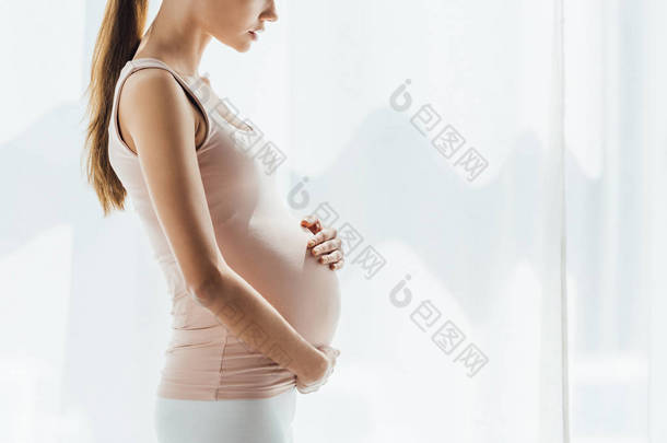 孕妇在家中摸肚子的剪影