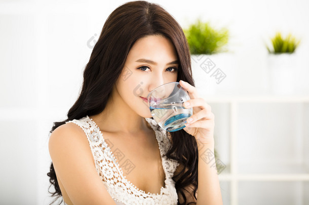 轻松自在的年轻微笑的女人喝着洁净的<strong>水</strong>