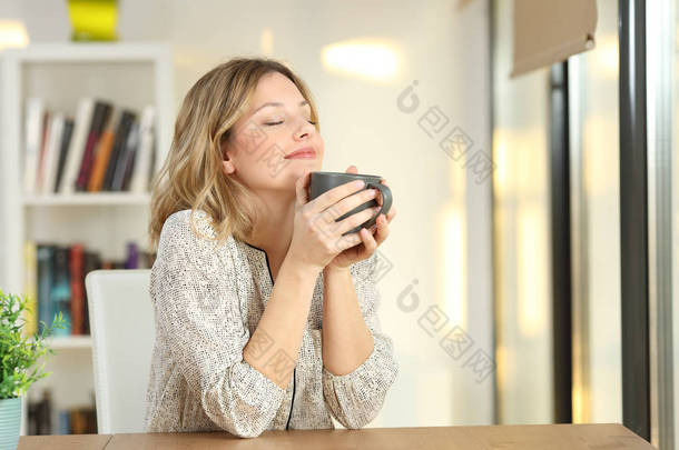 在家里拿着一个咖啡杯的妇女<strong>呼吸</strong>