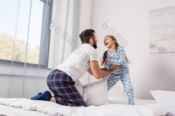 父亲和女儿在床上玩