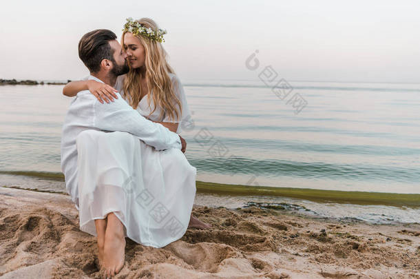 深情的新娘和新郎要亲吻海滩