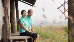 亚洲高级夫妻坐在凉亭旁稻田 