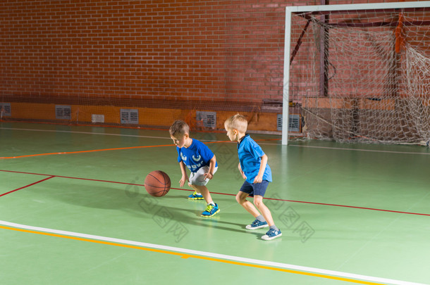 两个年轻男孩玩一场篮球比赛