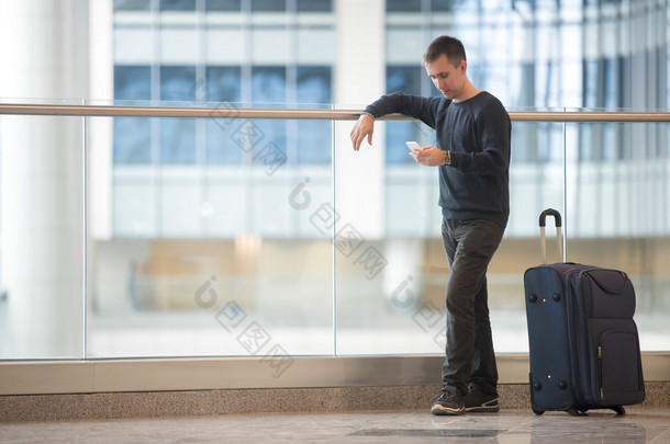 年轻的旅行者在<strong>机场</strong>中使用智能手机 