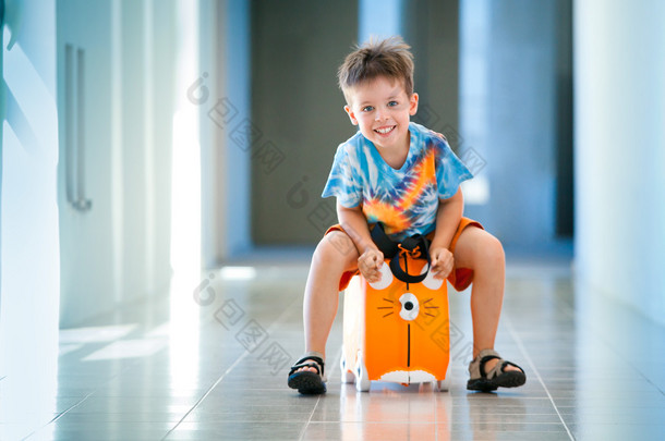 可爱<strong>快乐</strong>的孩子带着手提箱在机场