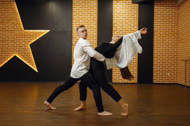 当代舞蹈演员夫妇在演播室接受训练 男女舞蹈演员在课堂上的锻炼、现代舞蹈、伸展运动
