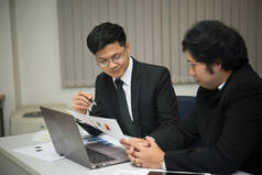 两个亚洲商人在谈论公司的业务，两个人在谈论工作压力和更严重的问题.