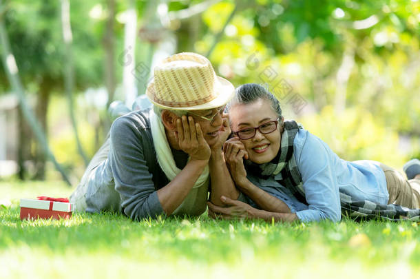 亚洲生活方式老年夫妇惊喜礼物特别一天在自然公园快乐和放松的时间。老人家庭休息和<strong>退休</strong>后在假期寒意.