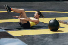 运动妇女做腹肌锻炼在户外健身房。健身 